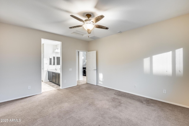 empty room featuring a ceiling fan, light colored carpet, visible vents, and baseboards