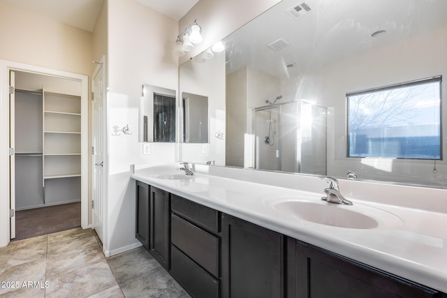 bathroom featuring double vanity, a stall shower, a sink, and visible vents