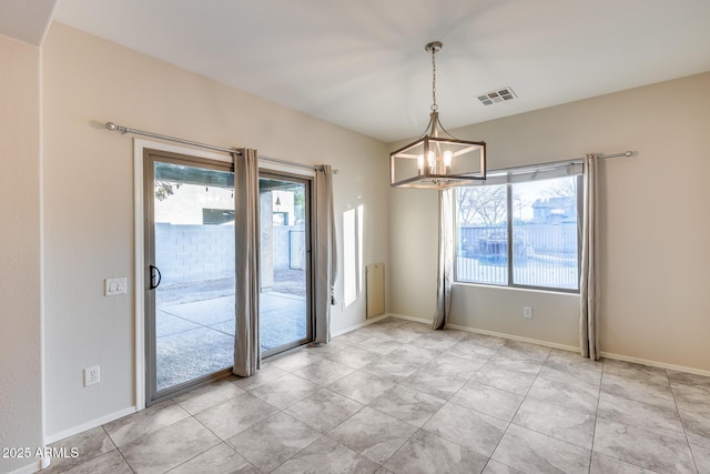 unfurnished room with baseboards, an inviting chandelier, visible vents, and a healthy amount of sunlight