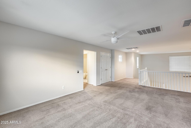 carpeted spare room featuring ceiling fan