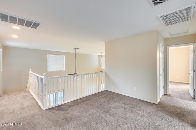 carpeted empty room with baseboards, visible vents, and recessed lighting