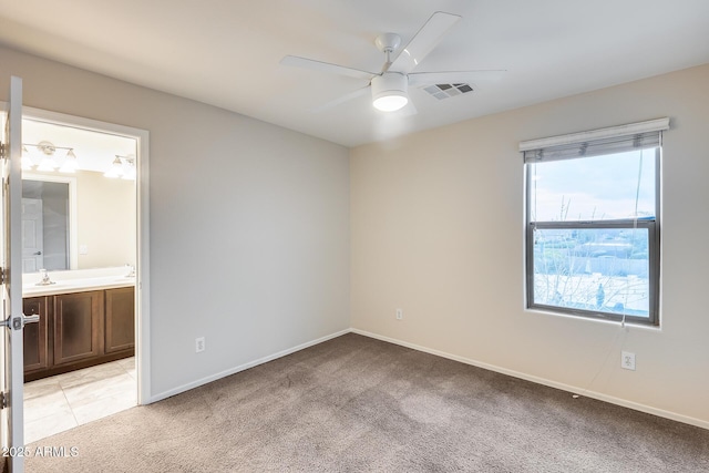 carpeted spare room with sink and ceiling fan