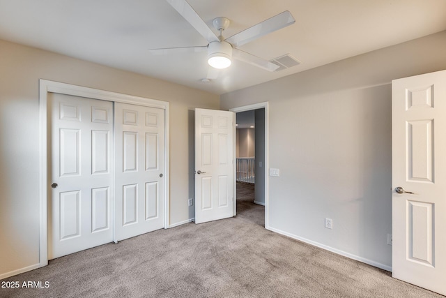 unfurnished bedroom with light carpet, a closet, and ceiling fan