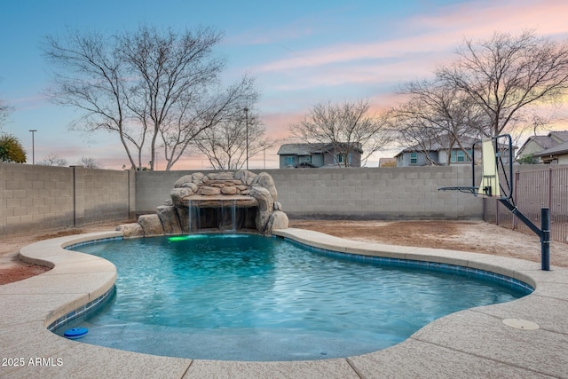 pool at dusk featuring pool water feature