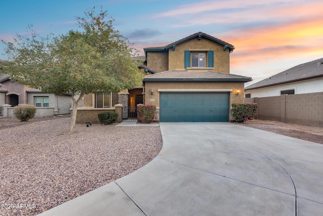 traditional-style home with an attached garage, fence, a tile roof, driveway, and stucco siding