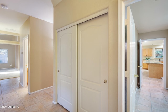 corridor with a healthy amount of sunlight and light tile patterned floors