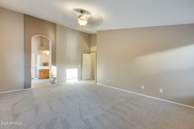 carpeted spare room featuring ceiling fan and high vaulted ceiling