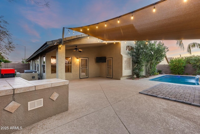 exterior space featuring pool water feature, ceiling fan, a fenced in pool, and a patio area