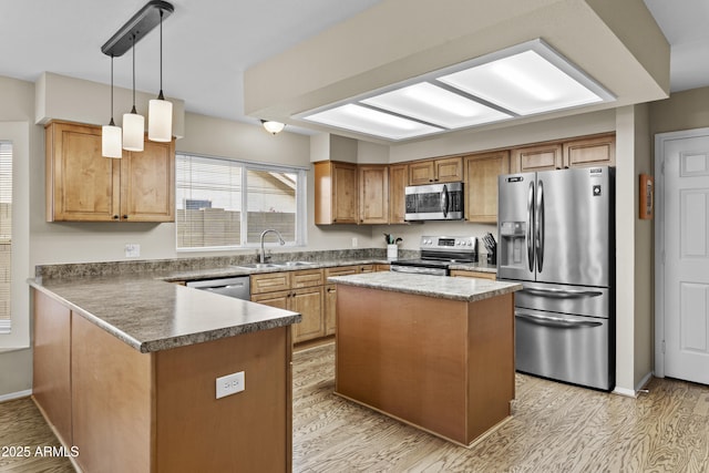 kitchen featuring pendant lighting, light wood-type flooring, a sink, a peninsula, and stainless steel appliances