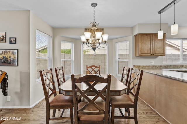 dining area with a healthy amount of sunlight, an inviting chandelier, and light wood-style flooring