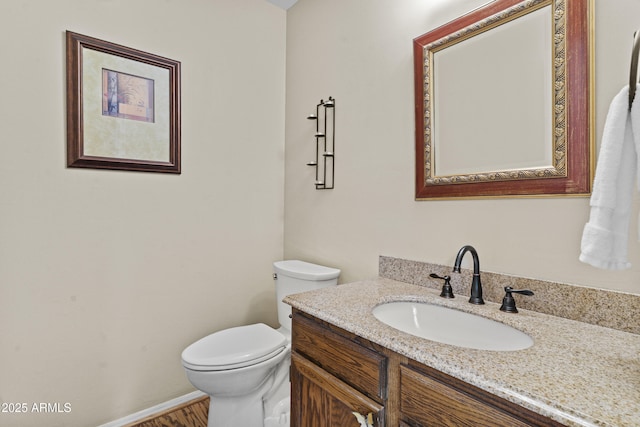 bathroom with vanity, baseboards, and toilet
