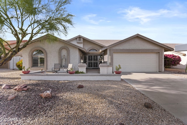 ranch-style house with a garage, stucco siding, and concrete driveway