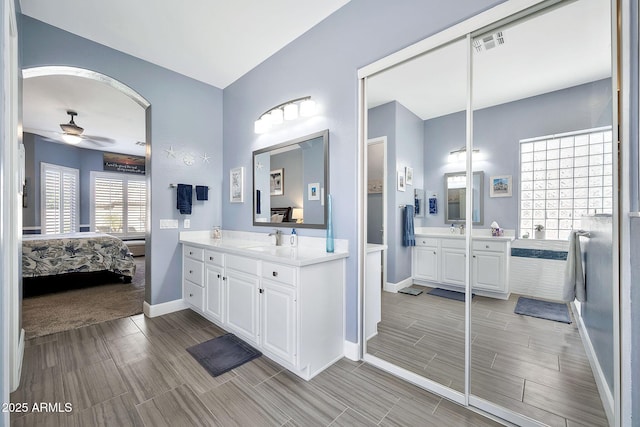 full bathroom featuring visible vents, two vanities, a sink, connected bathroom, and ceiling fan