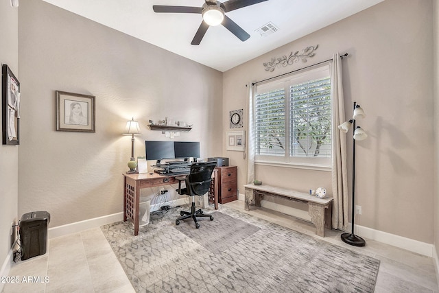 home office featuring tile patterned floors, visible vents, a ceiling fan, and baseboards