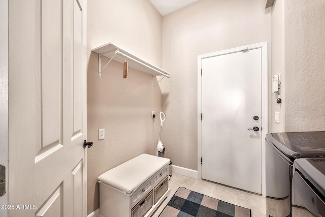 laundry area with laundry area, washer and dryer, baseboards, and a textured wall