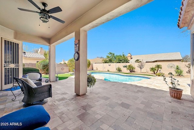 view of swimming pool featuring ceiling fan, a fenced in pool, a fenced backyard, and a patio area