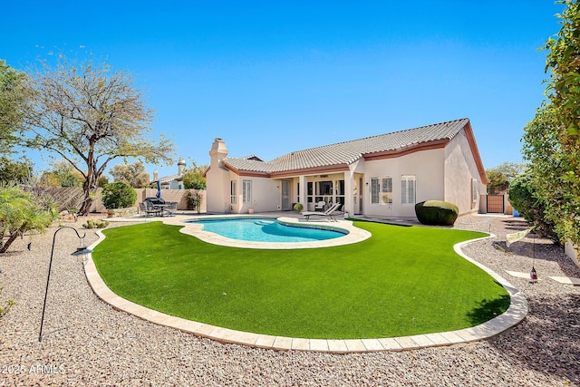 rear view of property featuring a fenced in pool, a tiled roof, stucco siding, a fenced backyard, and a patio