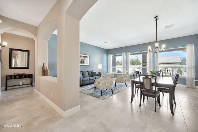 dining space featuring a chandelier, visible vents, baseboards, and light tile patterned floors