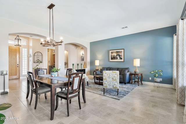 dining space with visible vents, arched walkways, and baseboards