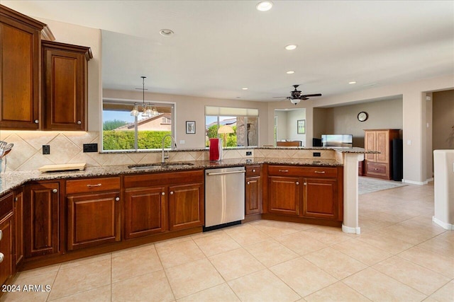 kitchen with sink, ceiling fan with notable chandelier, kitchen peninsula, light stone countertops, and stainless steel dishwasher