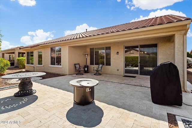 rear view of house featuring a patio and a fire pit