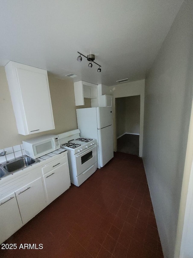 kitchen featuring white cabinetry, white appliances, rail lighting, and sink