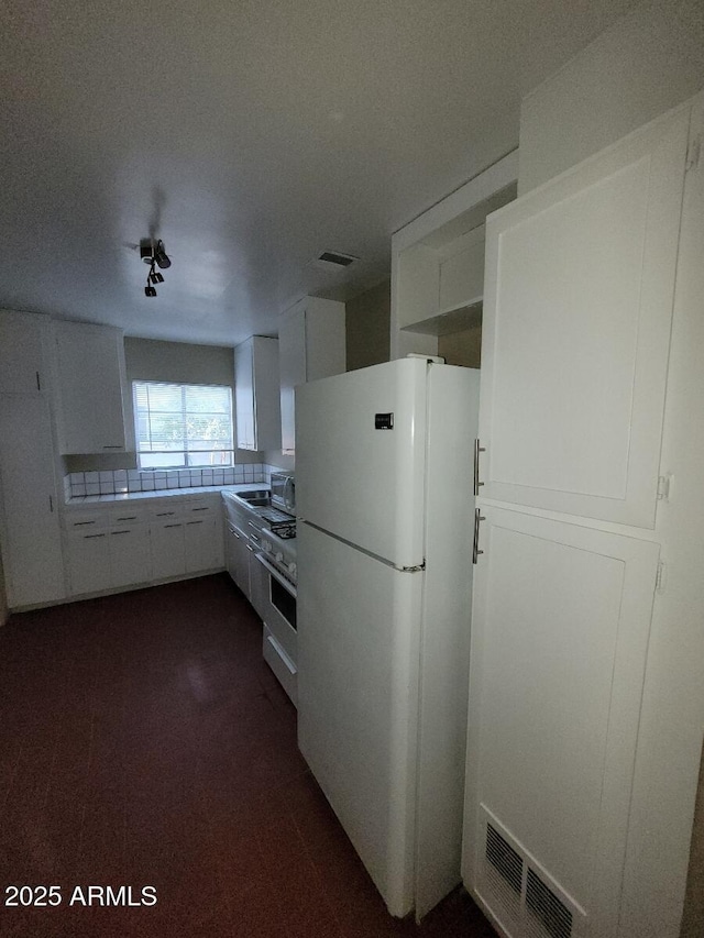 kitchen with white cabinetry, tile counters, and white appliances