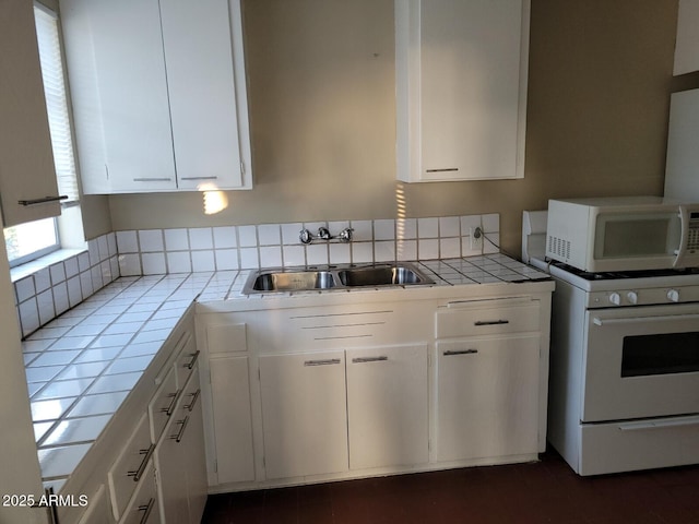 kitchen with white cabinetry, sink, white appliances, and tile countertops