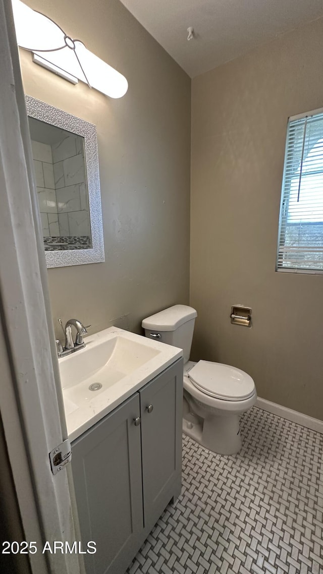 bathroom with tile patterned flooring, vanity, and toilet