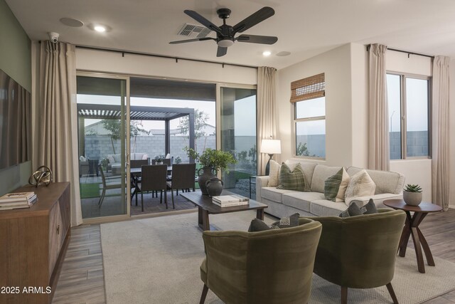 19022 W Rose Ln, Waddell, AZ 85355 - living area featuring wood finished floors, a healthy amount of sunlight, and a ceiling fan