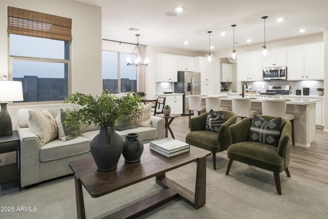 19022 W Rose Ln, Waddell, AZ 85355 - living area with visible vents, a chandelier, recessed lighting, and light wood finished floors