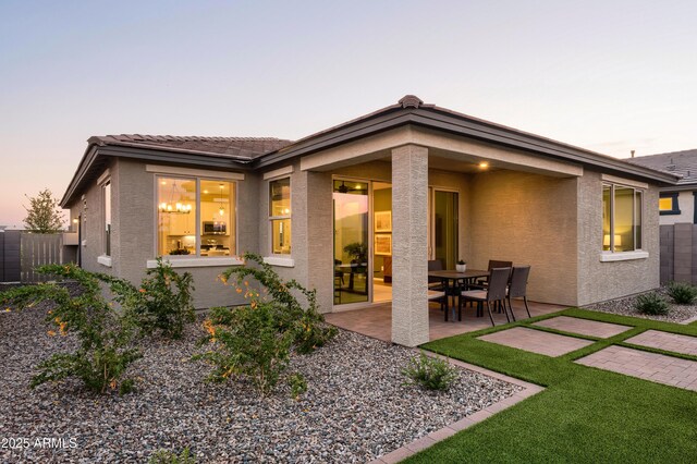 19022 W Rose Ln, Waddell, AZ 85355 - rear view of house featuring a tiled roof, stucco siding, fence, and a patio area