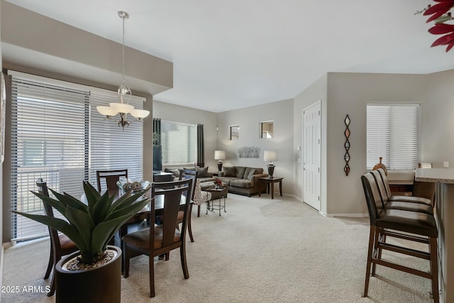 dining room featuring light colored carpet and a chandelier