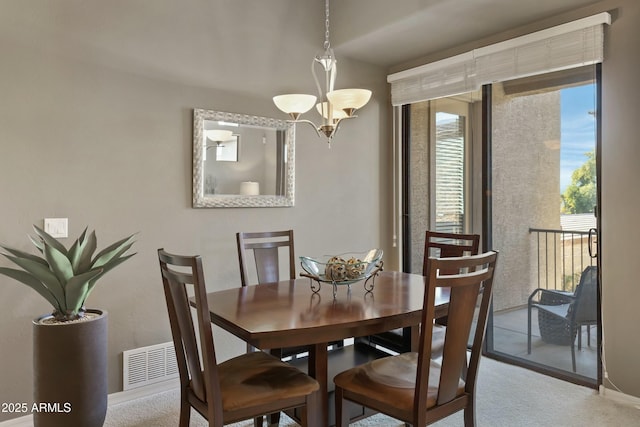 carpeted dining room featuring a notable chandelier