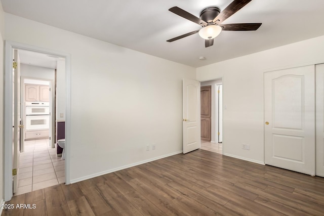 8538 E Vista Dr, Scottsdale, AZ 85250 - unfurnished bedroom with wood finished floors, a closet, and ceiling fan