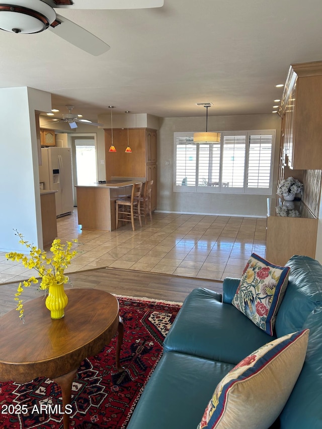 tiled living room with a wealth of natural light and ceiling fan