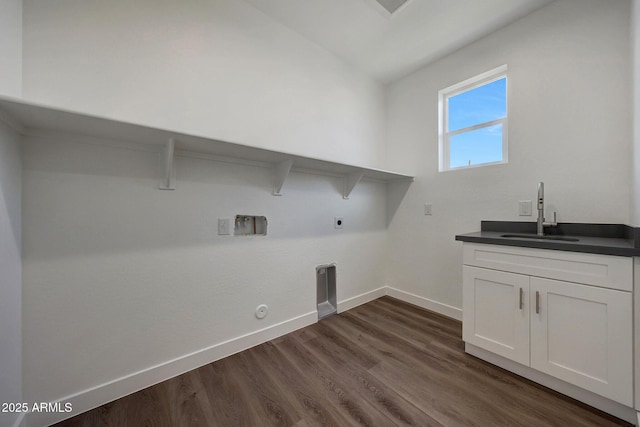 laundry room with baseboards, hookup for a gas dryer, dark wood-style floors, hookup for an electric dryer, and a sink