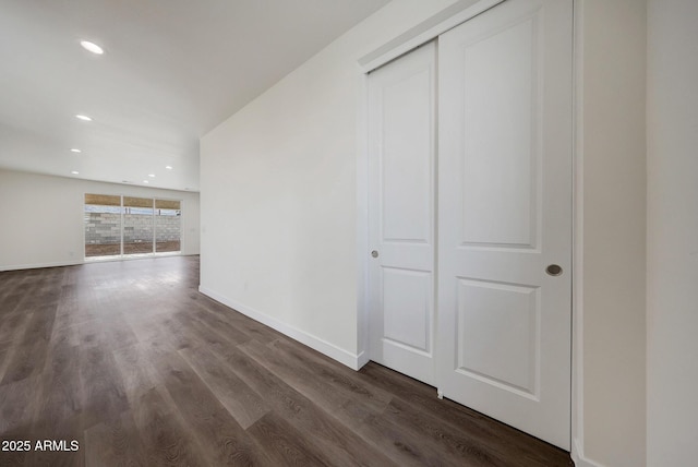 unfurnished living room with dark wood-style flooring, recessed lighting, and baseboards