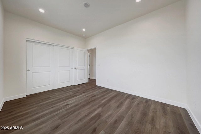 unfurnished bedroom with dark wood-style floors, recessed lighting, a closet, and baseboards