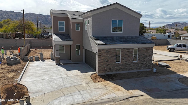 traditional-style house with stone siding, a mountain view, and stucco siding