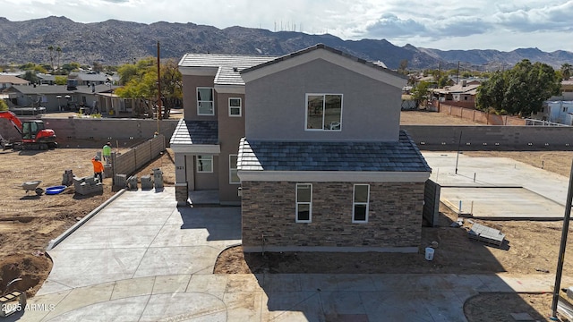 view of front of property with a residential view, fence, a mountain view, and stucco siding