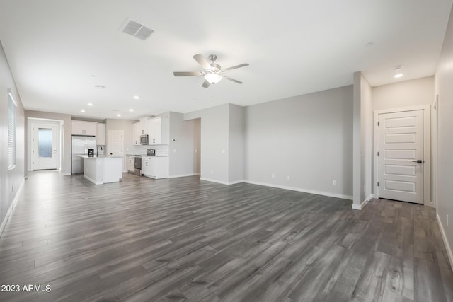 unfurnished living room featuring baseboards, visible vents, ceiling fan, dark wood-type flooring, and recessed lighting