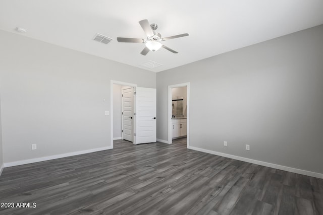 spare room featuring a ceiling fan, visible vents, baseboards, and dark wood-type flooring