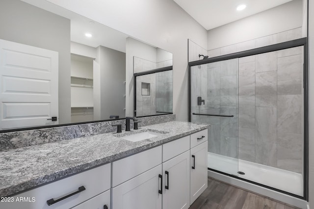 bathroom featuring recessed lighting, a shower stall, vanity, and wood finished floors