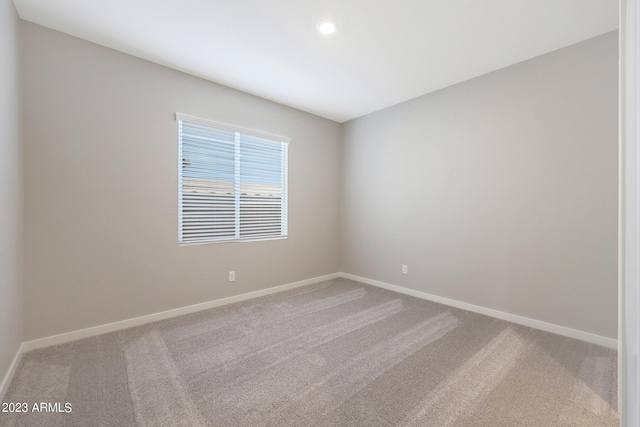 carpeted spare room featuring recessed lighting and baseboards