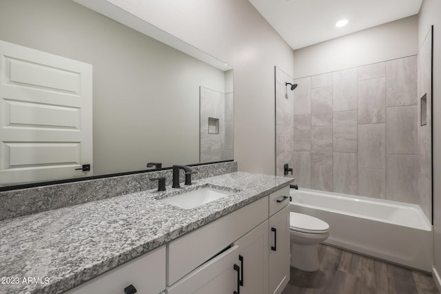 bathroom with recessed lighting, toilet, vanity, wood finished floors, and  shower combination