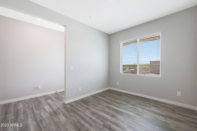 unfurnished room with wood finished floors and baseboards