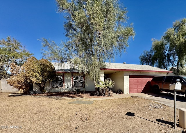 ranch-style home with concrete driveway and a garage