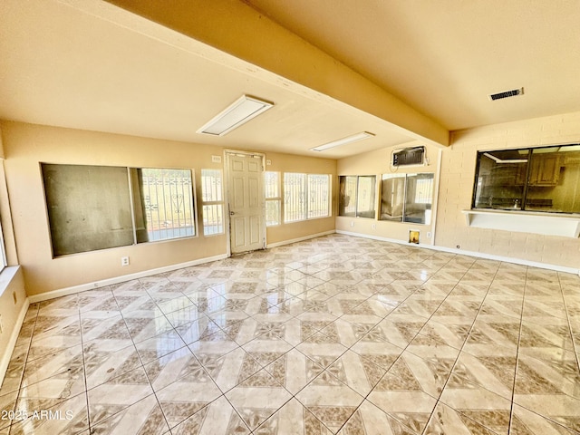 unfurnished room featuring beam ceiling, visible vents, and baseboards