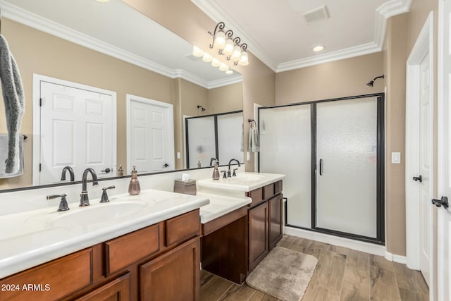 bathroom featuring vanity, hardwood / wood-style flooring, a shower with door, and crown molding